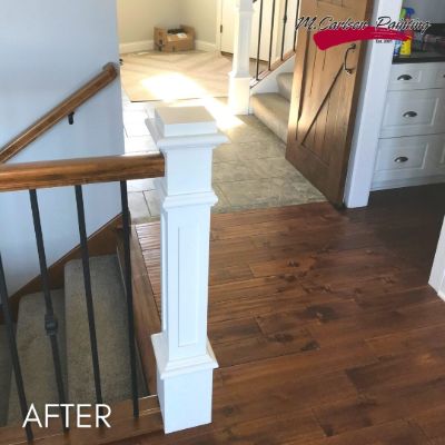 Stair newel post and rail, white posts below a stained oak handrail