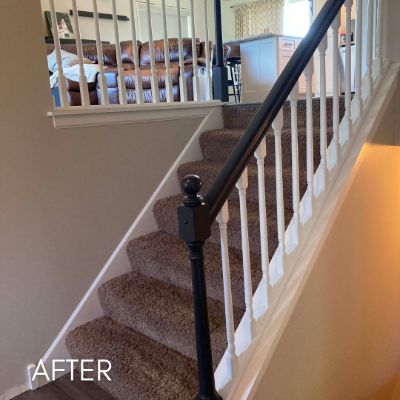 Staircase after painting, white balusters below a dark stained handrail