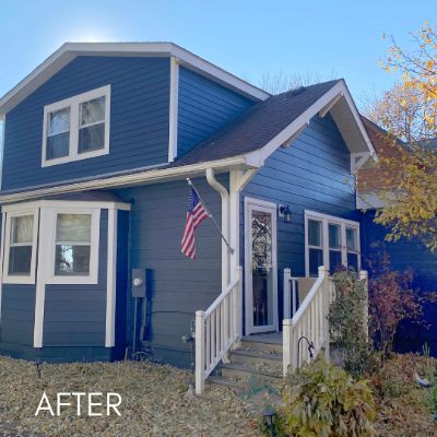 Two-story house in blue siding with white trim and a covered entry