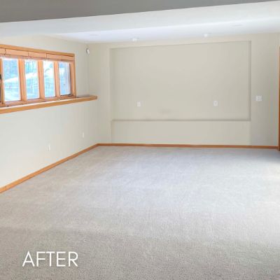 Empty living room after painting, cream walls above new carpet
