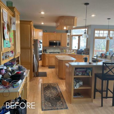 The same Prior Lake kitchen before refinishing, with honey oak cabinets and a cluttered counter