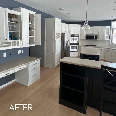 Prior Lake kitchen after refinishing, white cabinets and a black island against navy walls