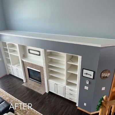 Built-in shelving and fireplace surround painted cream against blue gray walls