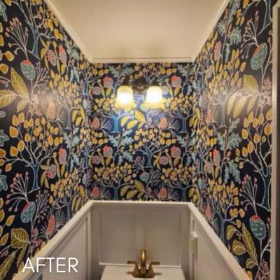 Powder room papered in a navy floral print above a white basin