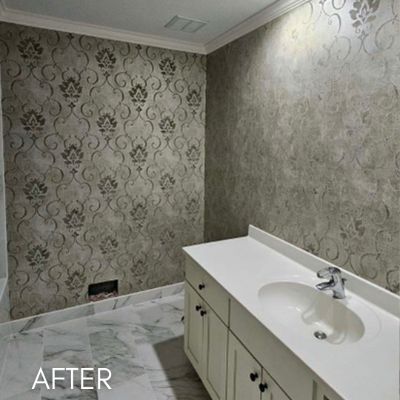 Bathroom papered in a gray damask print above a marble floor