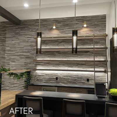 Bar wall hung with a striated wallcovering behind pendant lighting