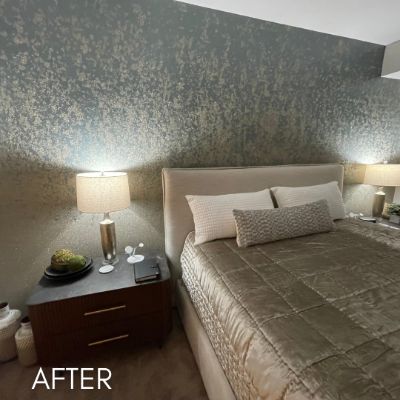 Bedroom hung with a mottled gold and green wallcovering