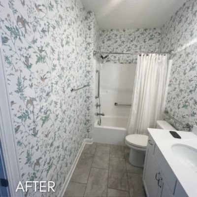 Bathroom papered in a fine botanical print around a shower and tub