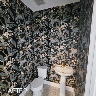 Powder room papered in a dark botanical print above a pedestal basin