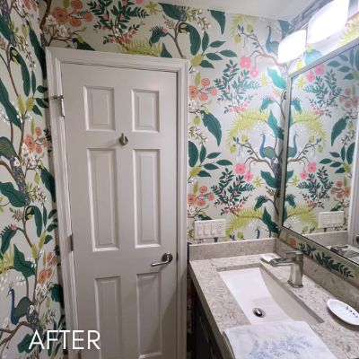 Bathroom papered in a bright botanical and bird print