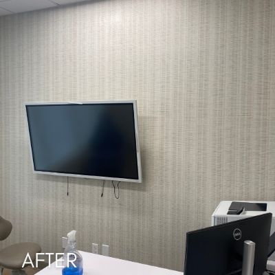 Office wall hung with pale grasscloth wallcovering behind a wall-mounted screen