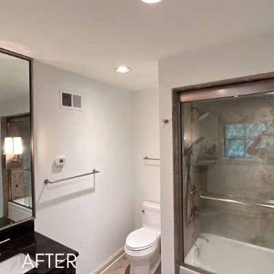 Bathroom after painting, white walls beside a tiled shower