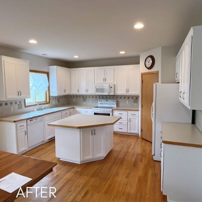 Waconia kitchen after refinishing, white cabinets and a center island under a pale gray ceiling