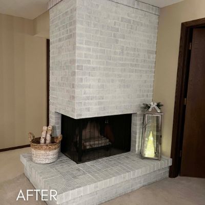 Brick fireplace after whitewashing, with a dark firebox