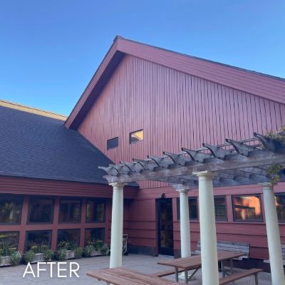 Barn red commercial building with a pergola over a paved patio