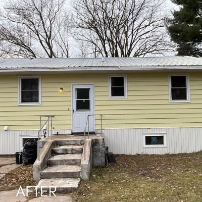 Single-story house in pale yellow siding with white trim
