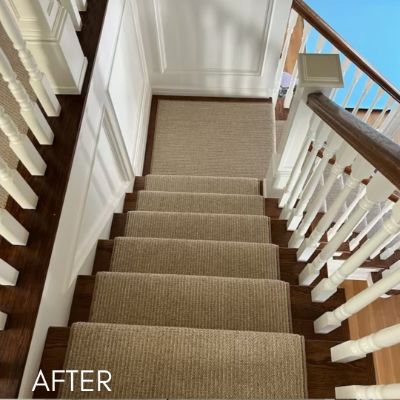 Staircase after painting, white balusters and panelled wall beside a carpeted run