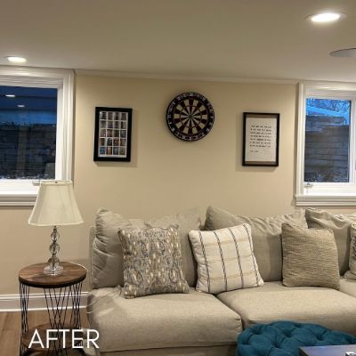 Basement living area after painting, warm beige walls between two windows