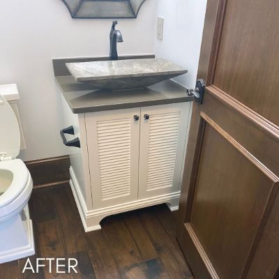 Bathroom vanity refinished white below a stone vessel basin