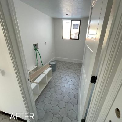Mudroom after painting, white walls and trim above hexagonal floor tile