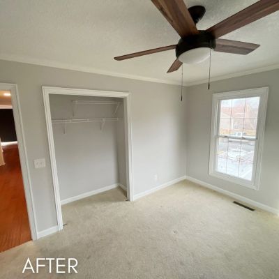 Empty bedroom after painting, warm gray walls beside a built-in closet
