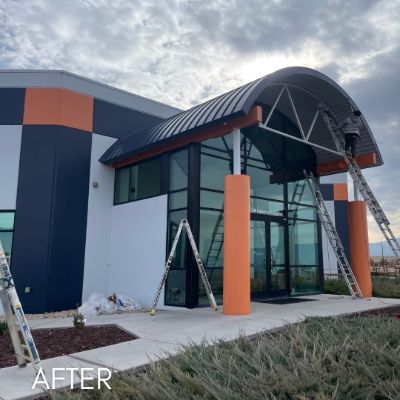 Commercial entrance in navy and orange with a curved metal canopy