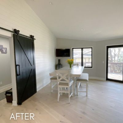 Dining area after painting, white shiplap wall beside a black barn door
