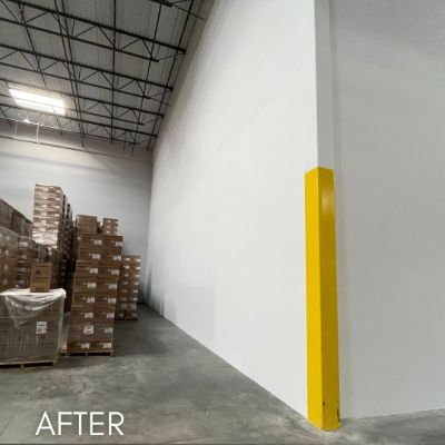 Warehouse interior after painting, white walls beside stacked pallets