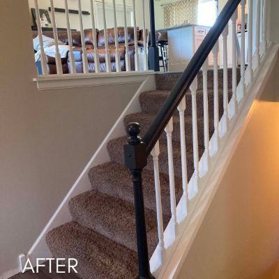 Staircase after painting, white balusters below a dark stained rail