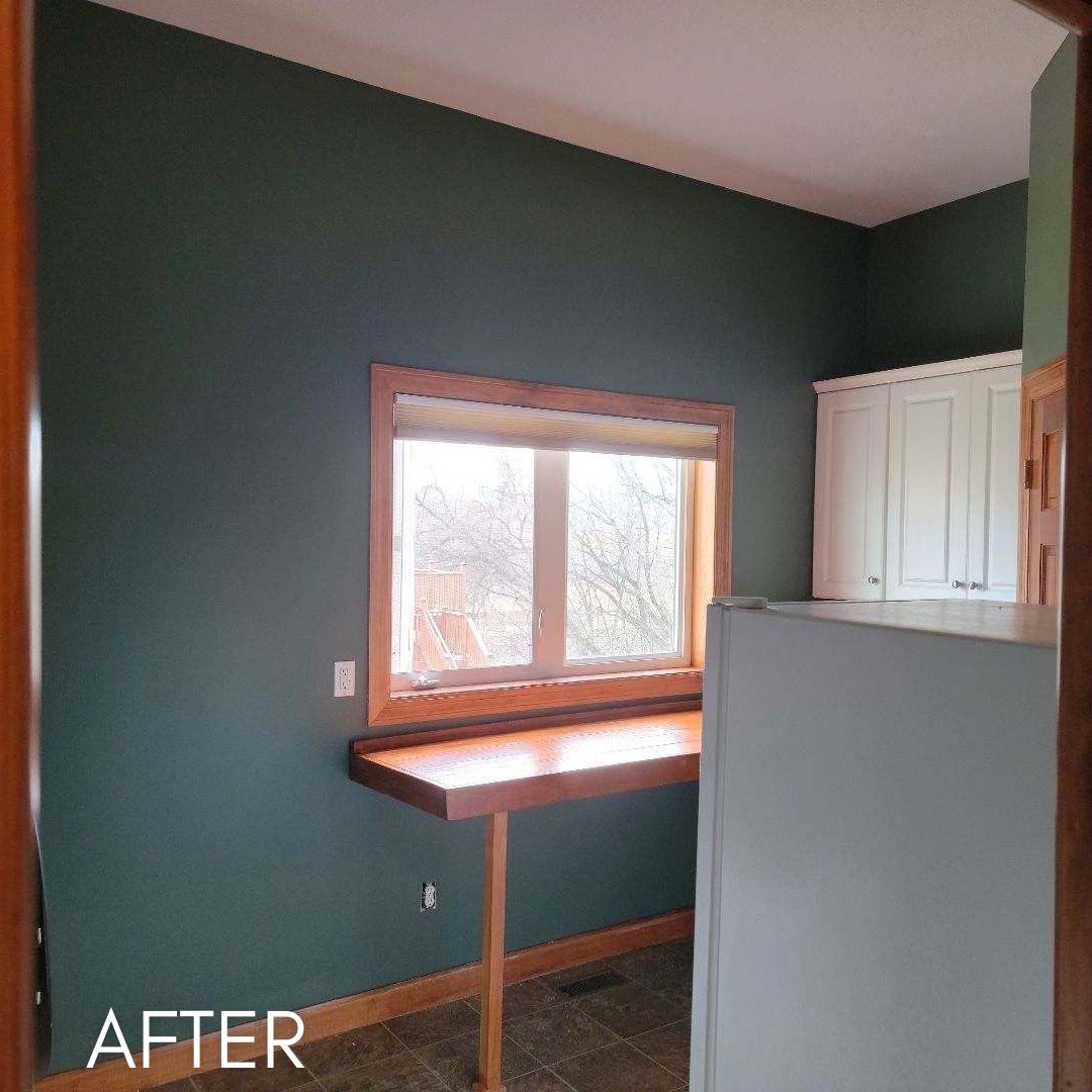 Laundry room after painting, deep green walls beside a white cabinet