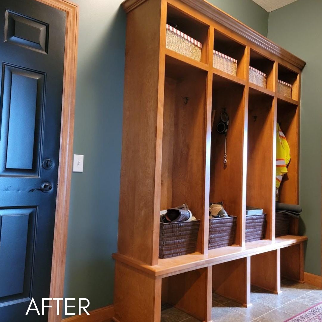 Mudroom after painting, a navy door beside wood lockers and cubbies