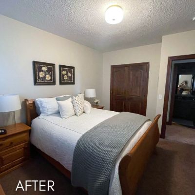 Bedroom after painting, soft gray walls beside a dark wood door