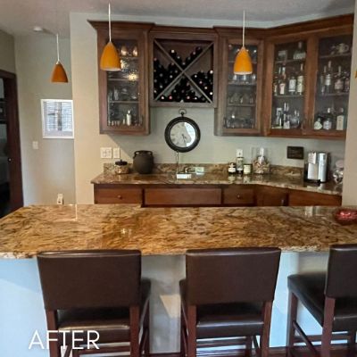 Kitchen bar with refinished dark cabinets and glass-fronted uppers above a granite counter