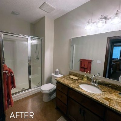 Bathroom after painting, pale walls above a dark vanity and granite top