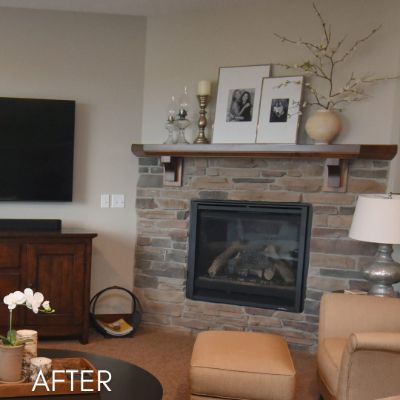 Stone fireplace and mantel in a living room after painting