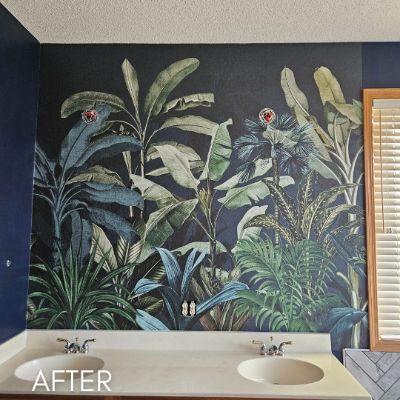 Bathroom hung with a tropical foliage mural above a double vanity