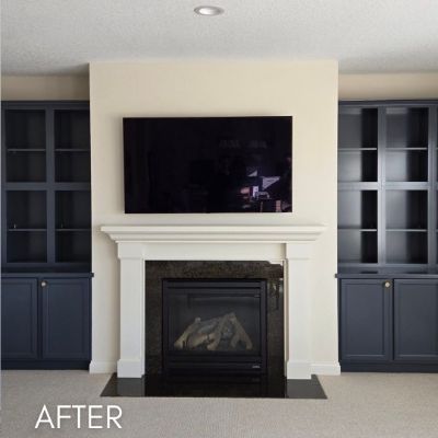 Fireplace surround enameled white between navy built-in cabinets