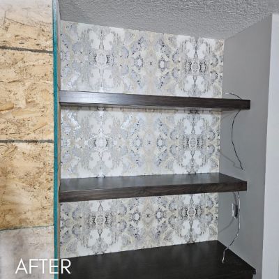 Bar wall papered in a silver medallion print behind floating shelves