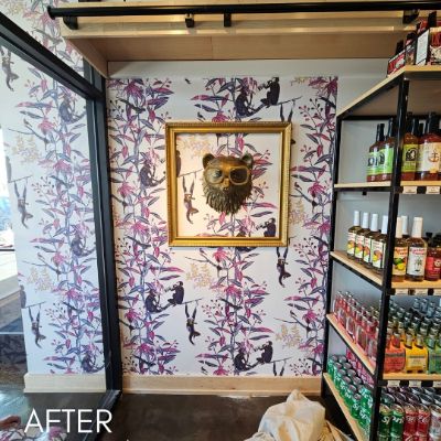 Shop interior papered in a bold monkey print beside stocked shelving