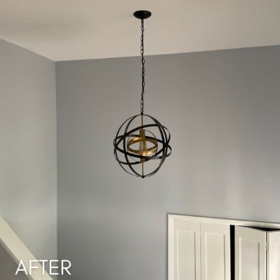 Hallway after painting, soft gray walls below a spherical pendant light