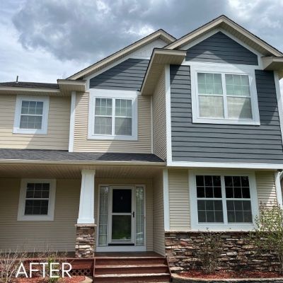 Townhouse in slate blue and cream siding with a stone-faced porch