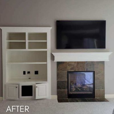 Fireplace surround and built-in shelving enameled cream around a tiled hearth