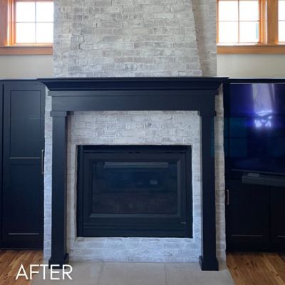 Fireplace mantel and flanking cabinets enameled navy against whitewashed brick