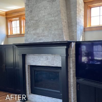 Navy fireplace surround and built-ins beside a whitewashed brick chimney breast