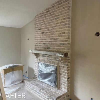 Brick chimney breast after whitewashing, with the fireplace masked off