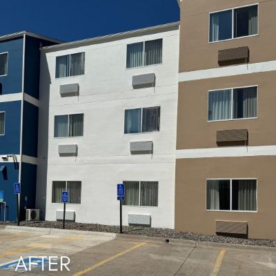 Hotel elevation in tan and white beside a blue stair tower