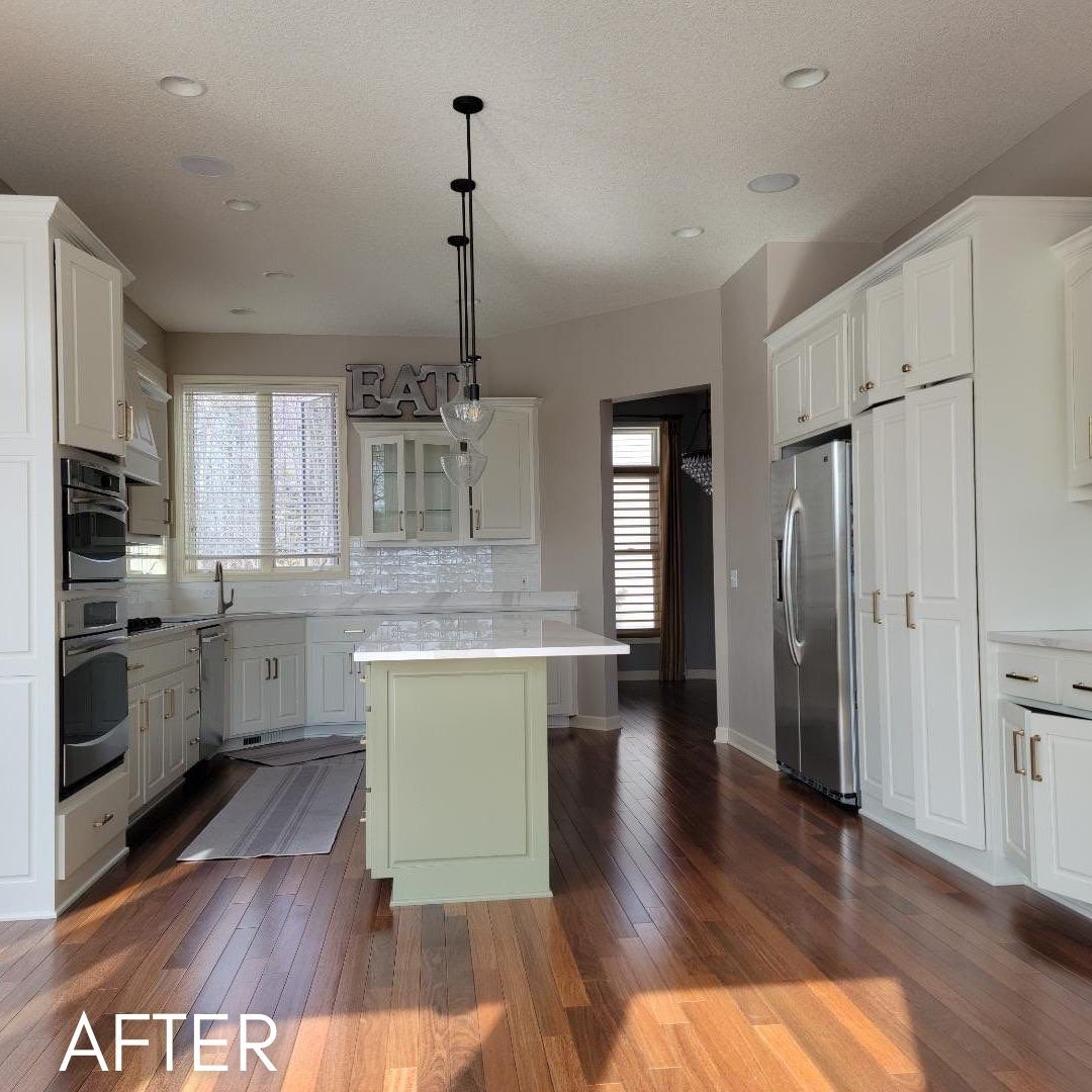 Kitchen after cabinet refinishing, cream cabinets and a sage green island
