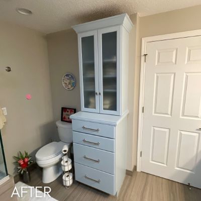 Bathroom linen tower refinished pale blue against a cream wall