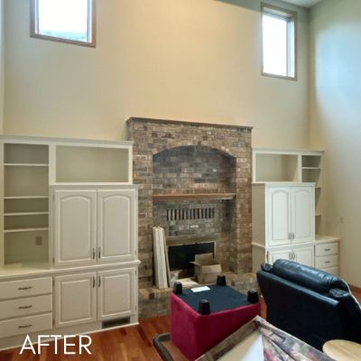 Built-in cabinetry enameled cream either side of a brick fireplace