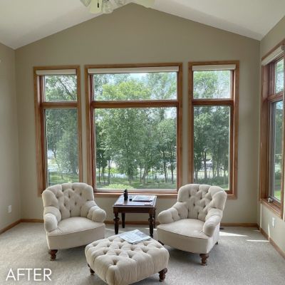 Living room after painting, sage walls around a bank of oak-framed windows